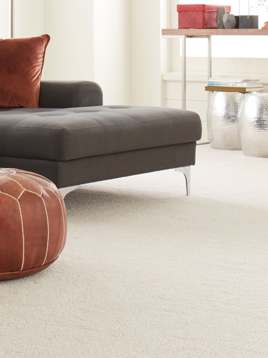 Woman sitting on a hardwood floor with a coffee mug in her hand.